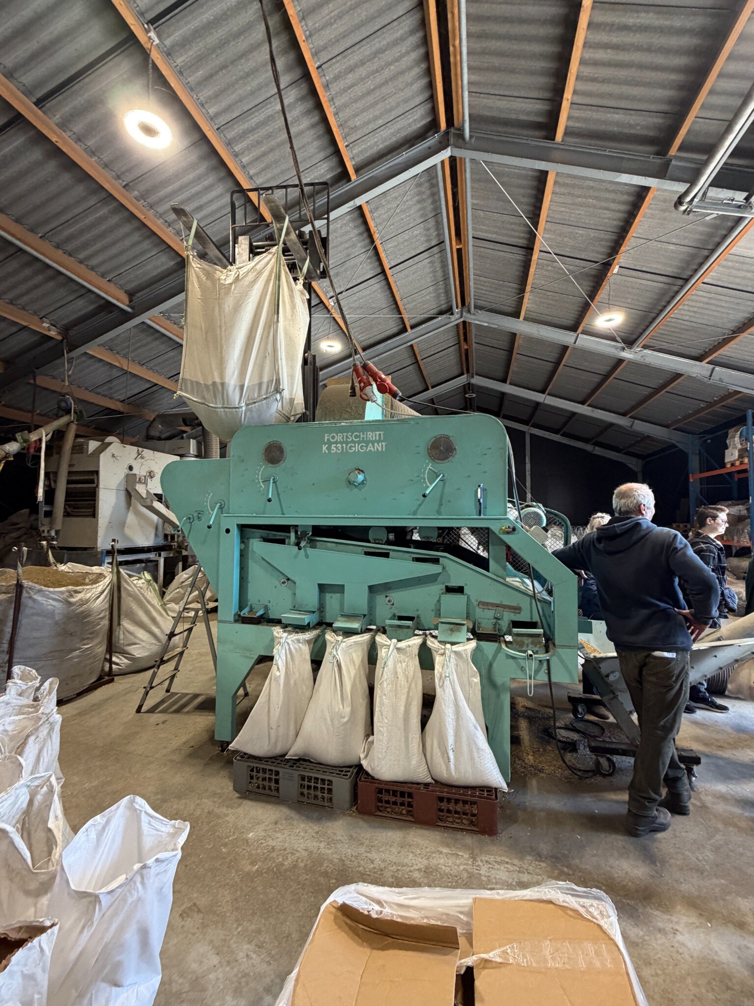 Participants observing seed processing equipment during a technical visit